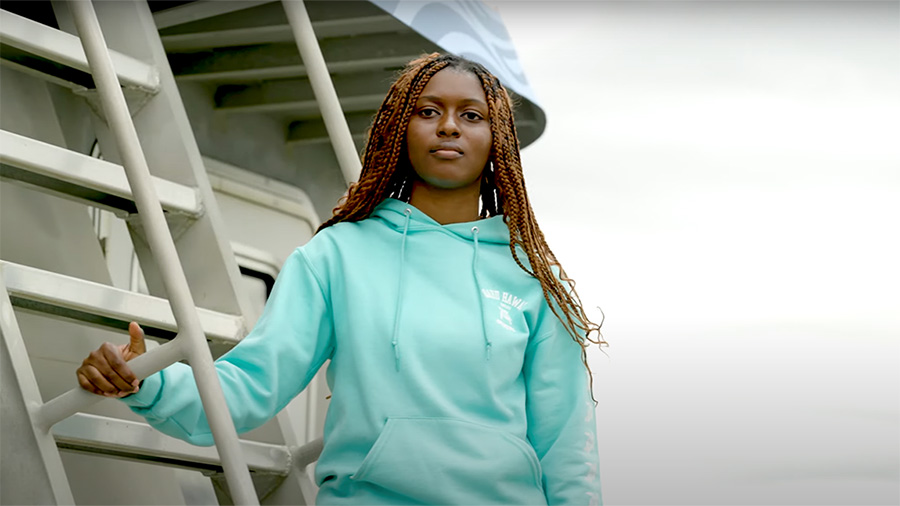 A student stands on the UMass Boston research boat and looks out at the water