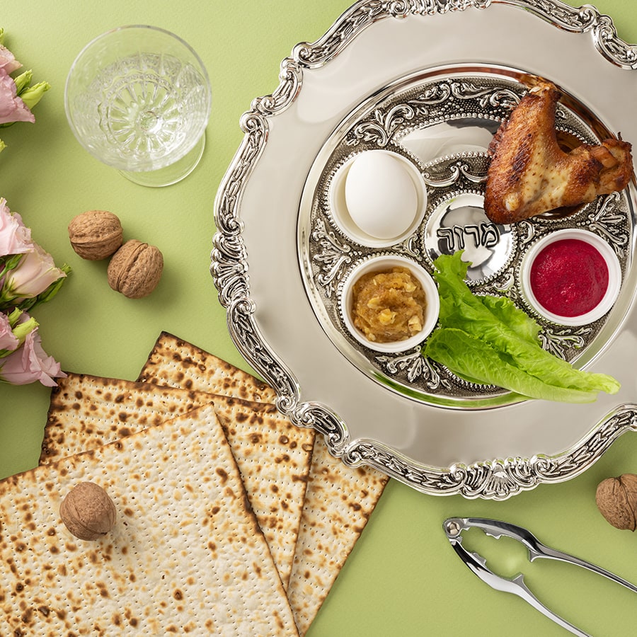 Elegant Passover setup featuring a seder plate, matzo bread, and decorative floral arrangement - stock photo
