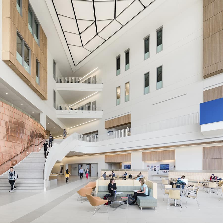 Students working in and walking through atrium.